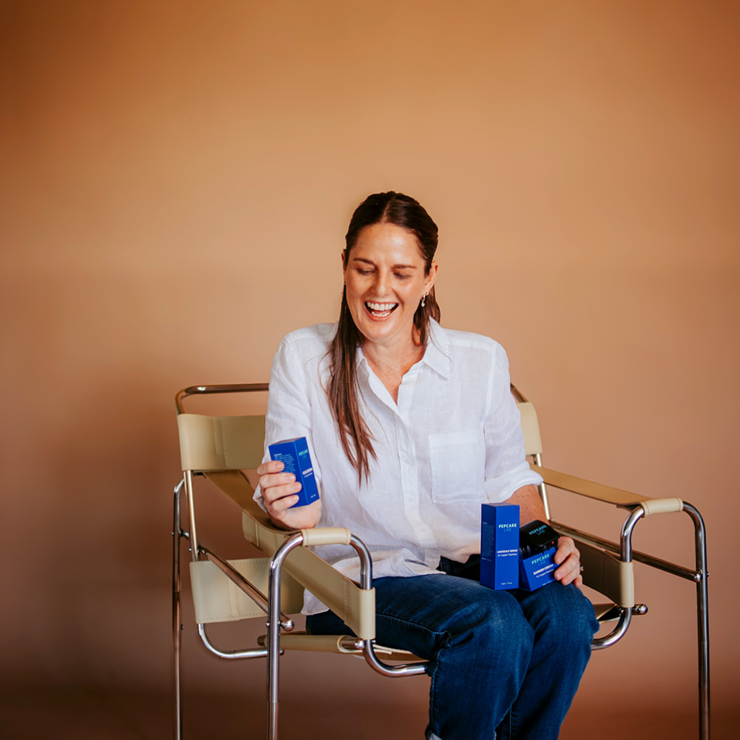 Marianne, founder of Pepcare Lab, seated with Pepcare Lab products